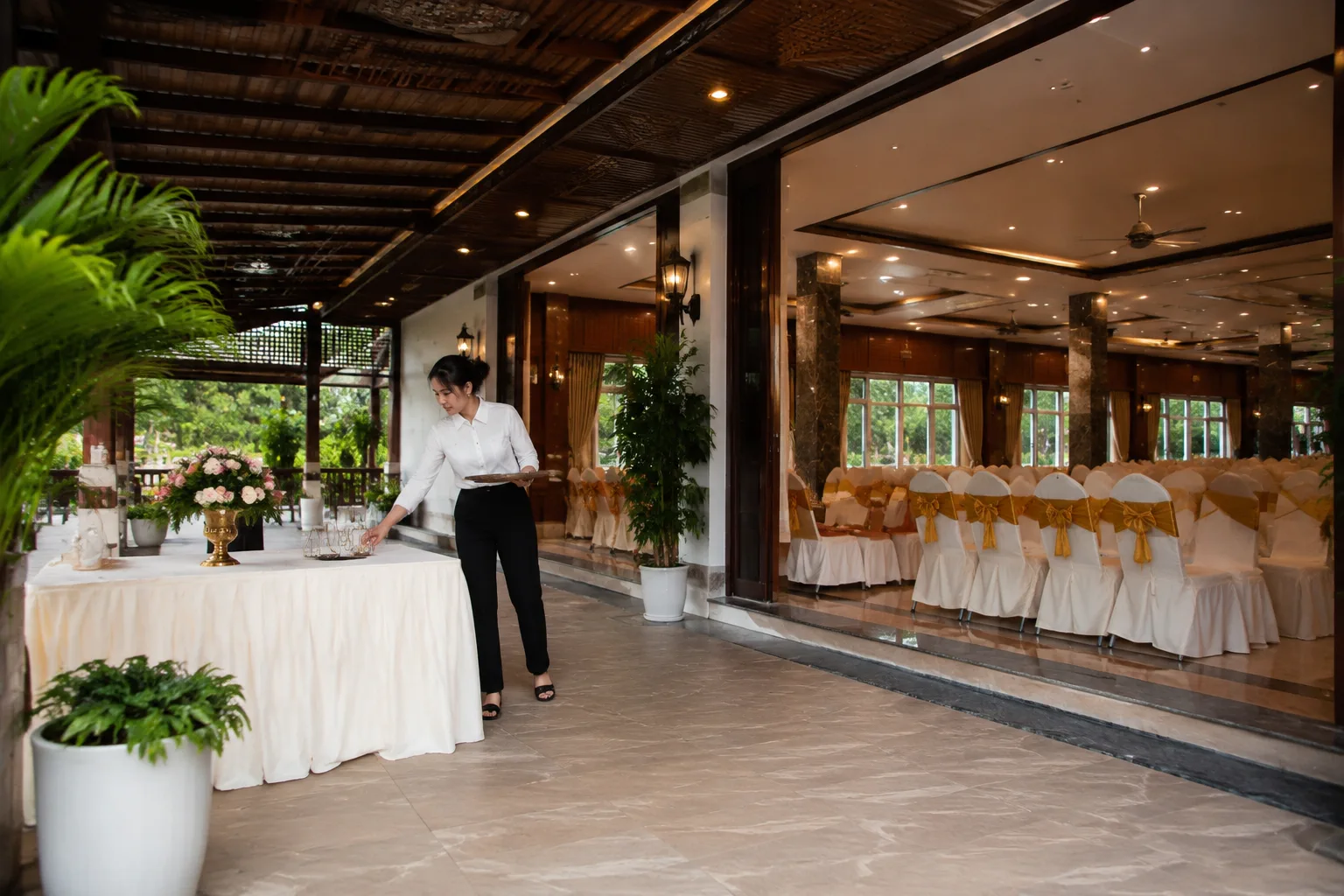 Không gian sảnh đón khách tại nhà hàng tiệc cưới Gia Nghĩa với lối vào rộng thoáng, nhân viên đang sắp xếp khu vực chào đón trước giờ diễn ra sự kiện, giúp người xem hình dung điểm