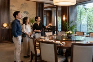 Người tổ chức sinh nhật người lớn cùng nhóm khách đang quan sát không gian phòng ăn riêng tại nhà hàng Việt Nam trước khi quyết định đặt bàn, thể hiện quá trình cân nhắc địa điểm v