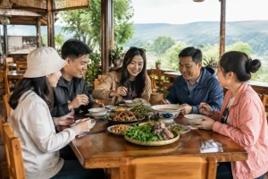 Du khách Việt Nam thưởng thức bữa ăn tại nhà hàng địa phương ở Đắk Nông với các món ăn được sắp xếp theo nhóm trên bàn, thể hiện việc lựa chọn thực đơn phù hợp cho hành trình khám