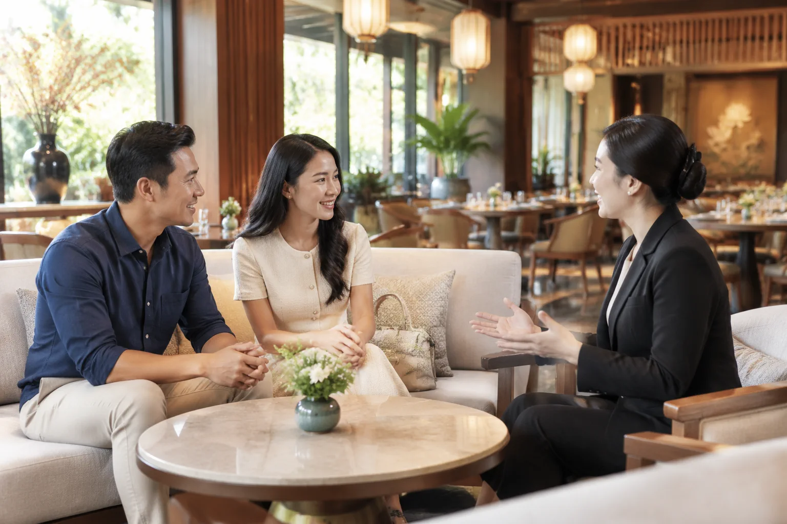 Khách hàng Việt Nam đang trao đổi ý tưởng tổ chức sự kiện với nhân viên nhà hàng trong không gian sảnh tiếp đón thoáng đãng, thể hiện sự chuẩn bị nhu cầu trước khi tư vấn.